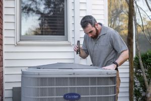 technician inspecting outdoor hvac unit